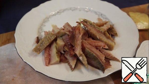 Remove the fillet from the herring, carefully check for small bones, try to get rid of them as much as possible fillet. Cut the fillet into small pieces and put it in a dish.