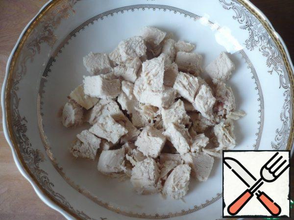 Boil the chicken fillet, and then cut into small cubes.