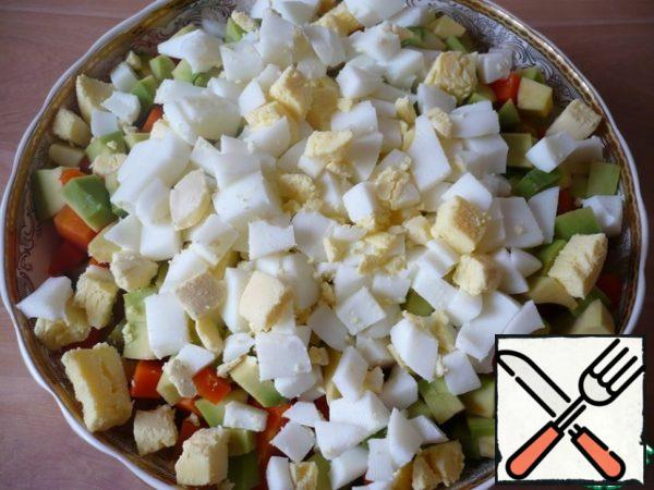 Boil the chicken eggs, peel and cut into cubes. Put in a bowl.