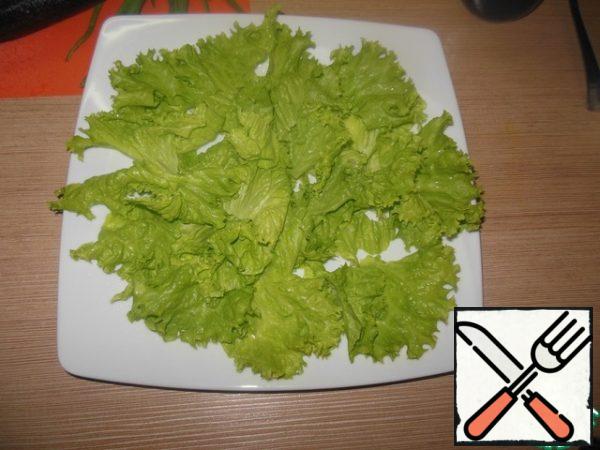 Put the lettuce leaves on the dish.