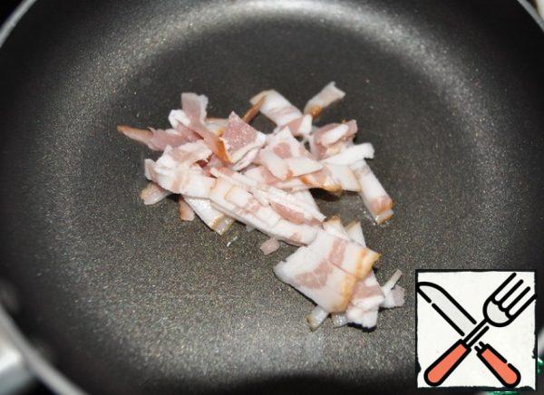 Cut the bacon into thin strips and fry for a couple of minutes in a frying pan.
