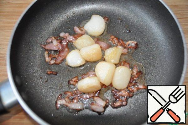 Dry the scallop with a towel and put it to the bacon, fry for 1 minute on each side.