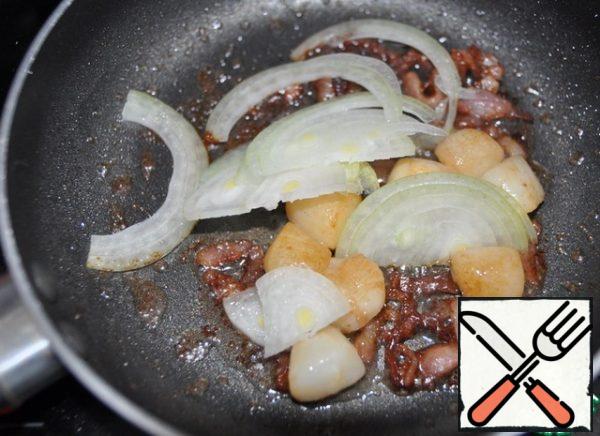 Cut the onion into thin half-rings and put it to the scallop, stir, fry until transparent.