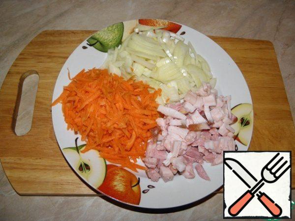 Cut the onion into half rings and grate the carrots.
Cut the pork belly into small pieces.