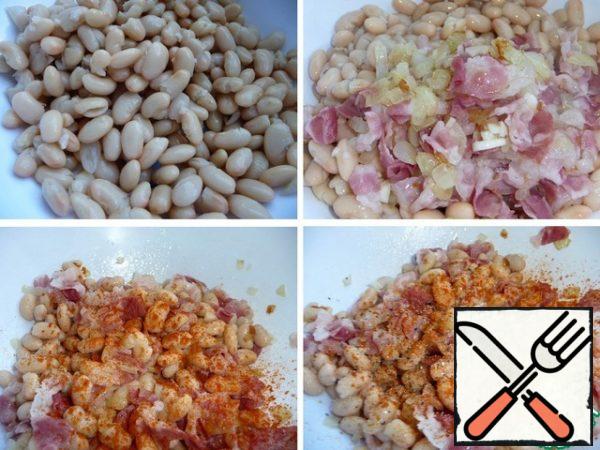 In a salad bowl, put the beans, add the bacon with onions and garlic, season with red and black pepper, lightly salt (be careful with salt, bacon and olives are salted).