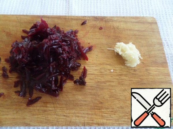 Grate on a coarse grater, add boiled beets. Chop the garlic.
