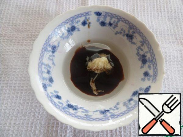Prepare the salad dressing by mixing vegetable oil, soy sauce and crushed garlic.
