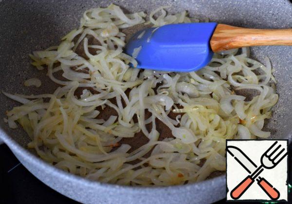 Cut a large onion into thin half rings and fry until soft in sunflower oil.
