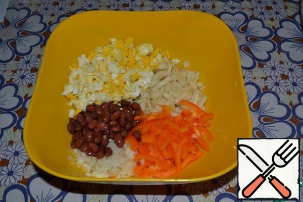 In a separate bowl, combine canned beans, pickled pears, onions, bell peppers and boiled eggs, cut into cubes.