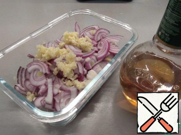 Red onion cut into half rings, garlic press a press and mix everything together.
For the marinade, type a glass of hot (but not boiling water, or the onion will cook) water, add salt, sugar and vinegar. I used wine, but taking into account the ratio of the volume of water and vinegar, I assume that the table can be taken in the same volume.
Carefully stir and pour into the form with the onion and garlic, the water should cover them completely, if not enough-just add more hot water.
Close the lid and leave to marinate for an hour.