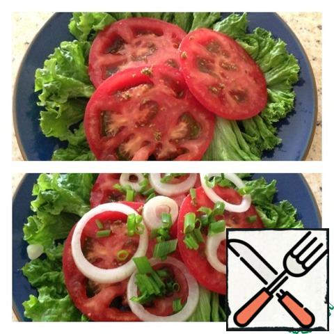 Put lettuce leaves on a plate. Cut the tomatoes into thin rings and place them on the lettuce leaves. Cut the onion the same way as the tomatoes and put it on top. Next, finely chopped green onions. Add salt and a pinch of suneli.