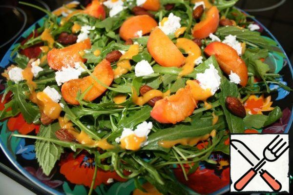 Put the sliced apricots on the arugula and mint leaves, crumble the feta and sprinkle with salted almonds. Pour the fragrant marinade and enjoy!