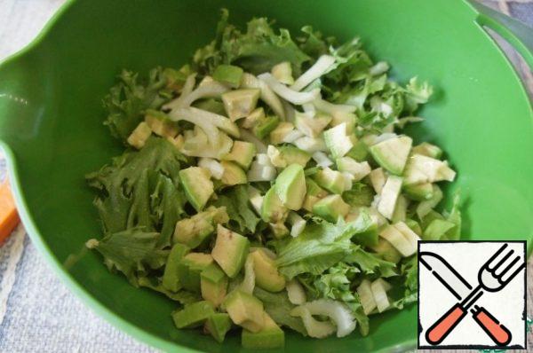 Peel the celery from the veins and cut it diagonally into thin slices.
Peel the avocado, remove the seed, and cut it into random slices or slices. Add both to the salad leaves.