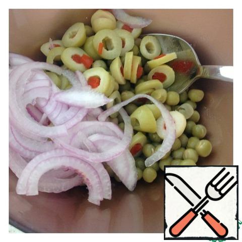 Drain the excess liquid from the peas and put 4 tablespoons in a salad bowl. Add onion, cut into half rings, and olives, cut into rings, to the peas.