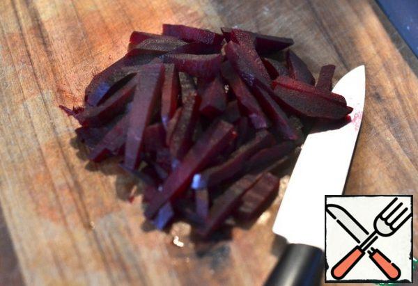 Peel the beets and cut them into strips.
Add to the cooled potatoes.