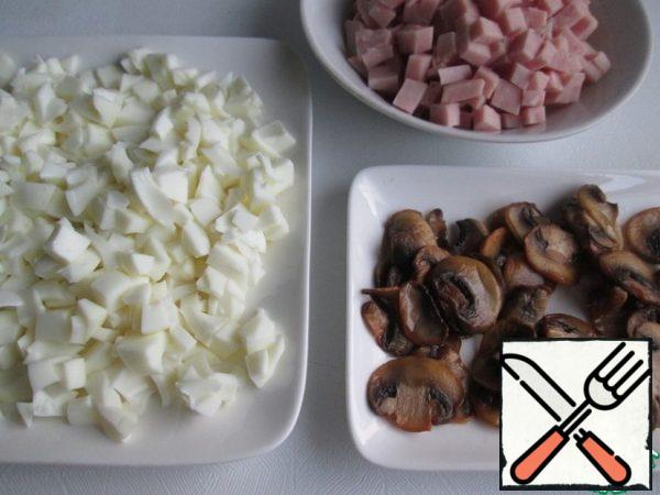 For the salad, finely chop the egg whites.
Take the ham to taste and desire, I have a ham sausage here. Cut it into cubes.
Let the fried mushrooms cool.

