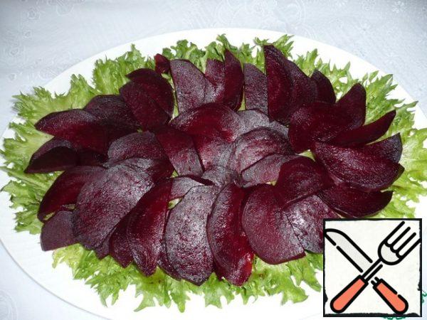 Boil the beets. (This can be done in advance, since the beet salad should be cold). Peel the beets, cut into half rings and put on lettuce leaves.