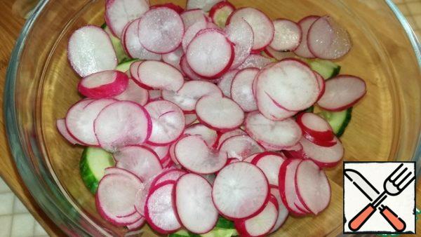 Cut the tails of radishes, wash and cut into circles. We send it to a bowl with cucumbers.

