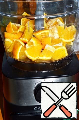Pour boiling water over the oranges and wash them thoroughly. With one orange, remove the peel and cut into parts, the second cut directly in the peel. Put it in the bowl of the blender, after installing the chopper attachment.