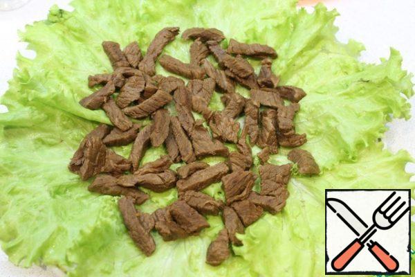 Put the lettuce leaves on the dish and the cold beef on top.
