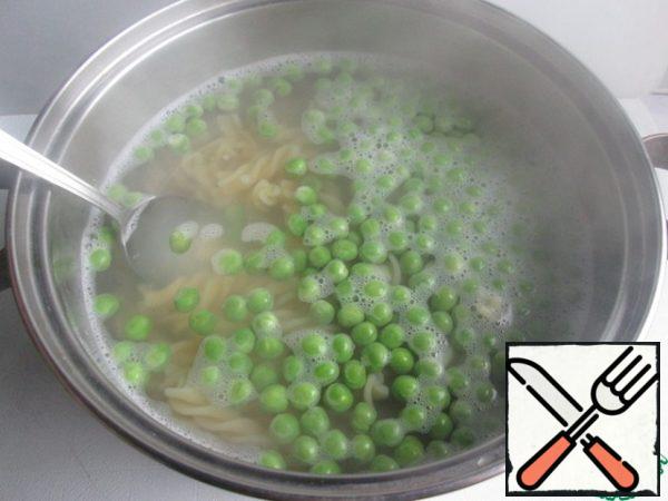 Boil the pasta in salted water according to the instructions on the package. 3 minutes before the end of cooking, add the green peas to the pasta ( here the peas are frozen).