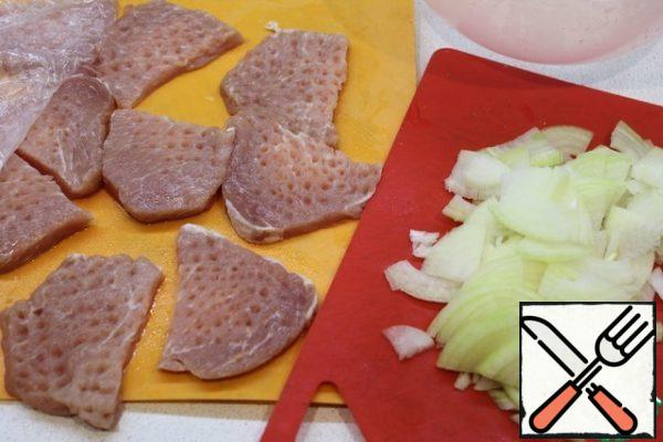 Cut the meat into pieces and beat it well on both sides. Cut the onion into half rings.
