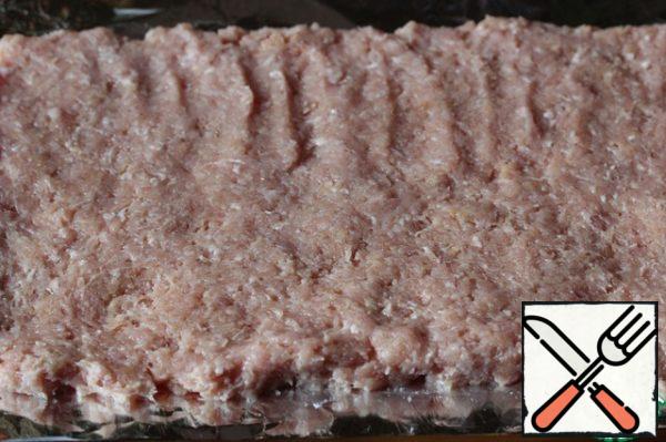 Place the minced meat on a double sheet of foil in the form of a long rectangle.
