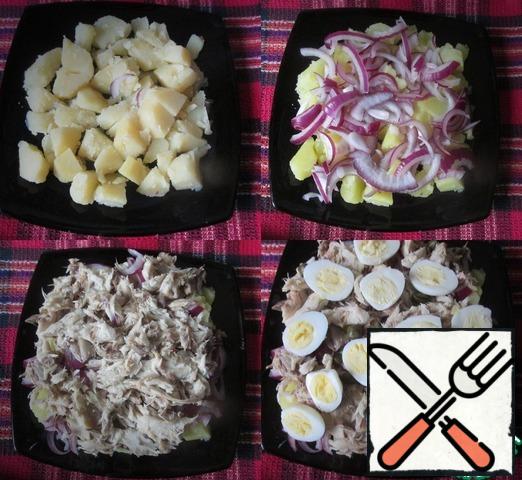 Cut the potatoes into medium cubes and spread on a dish in one layer. Put the onion on the potatoes. Put the mackerel on the onion.
On top of the fish distribute capers. Eggs cut in half and spread on top. I added salt to the salad, there is enough of it in fish and capers.
