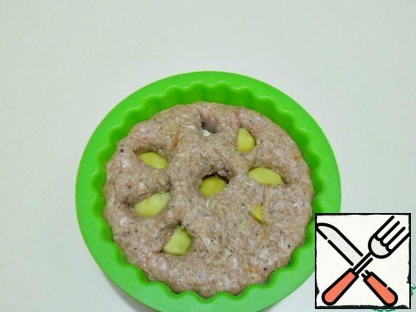 Roll the potatoes in minced meat. Carefully and tightly cover the potatoes with this minced meat. Smooth the surface with a wet spoon.
Shake the mold slightly and, as if "patting" it, so that the contents are compacted.
