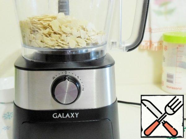 I will prepare the dough using a food processor with a chopping knife.
In a bowl, pour the almonds (I used almond petals),