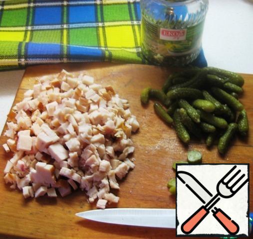 Boil pasta, throw in a colander, let the liquid drain and cool (for salads, it is convenient to use small products, I have small bows).Boil hard-boiled eggs, grate on a grater.Cut small pieces of smoked chicken breast and pickles.