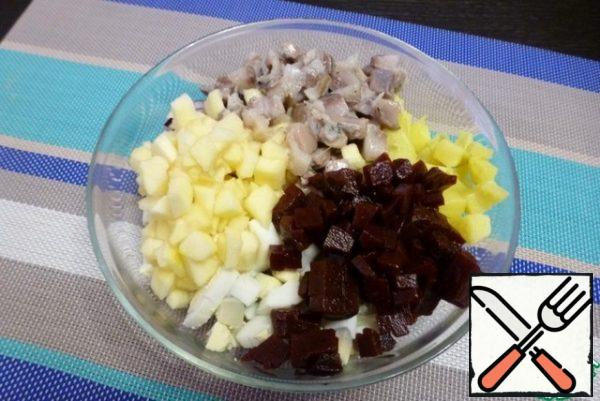 Cut the salted herring and pickled beetroot into cubes. Mix the slicing in one bowl.