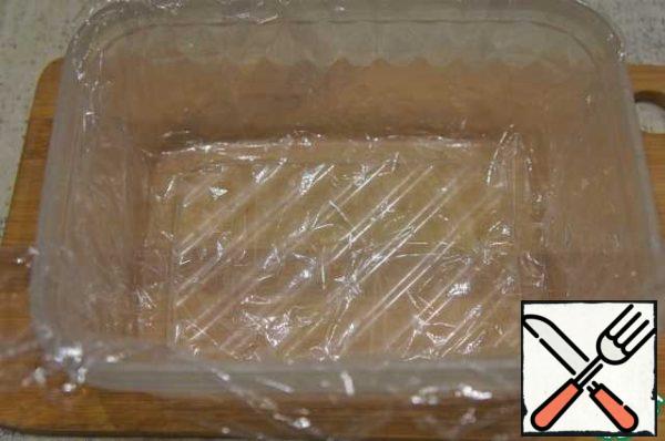 Cover a suitable container with cling film.