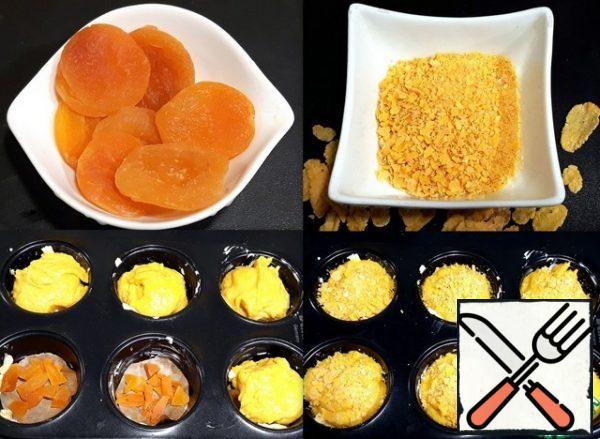I made dried apricots for the filling. She washed it,
cut it into slices and put it on the bottom of the greased
oil-shaped cells in the form of circles cut from
parchment paper. Spread the dough on dried apricots.
Sprinkle the dough
with crushed cornflakes on top.
