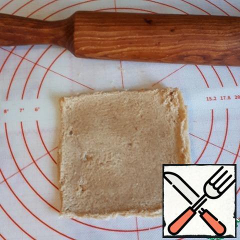 Roll out the bread with a rolling pin. If the bread is not fresh enough, put it in the microwave for five seconds, so it will be easier to roll out.