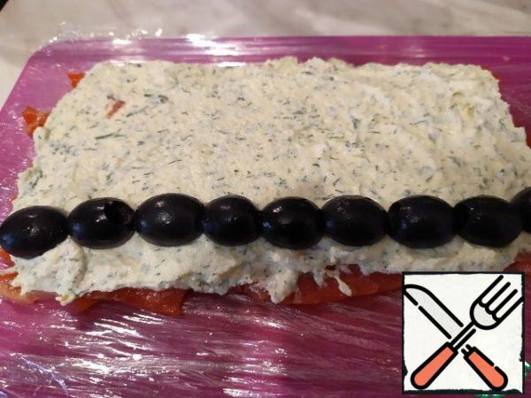 The resulting mass is spread on the fish and put a layer of olives on top.