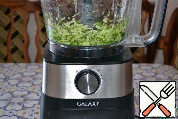 Grate the fresh cucumber on a coarse grater. A food processor coped with this task in a couple of seconds.
