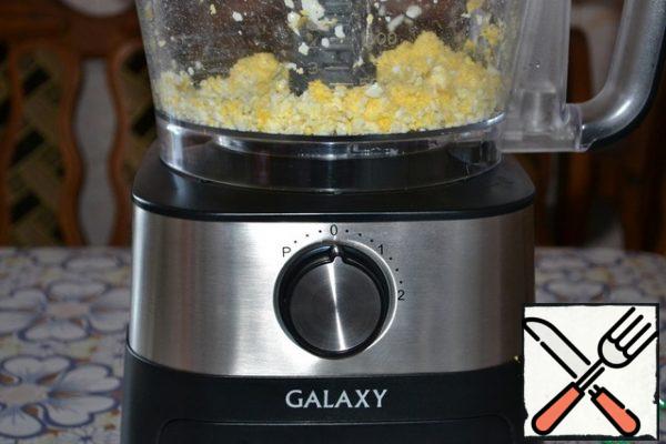 Grate the eggs on a coarse grater. And the food processor easily coped with this task.
