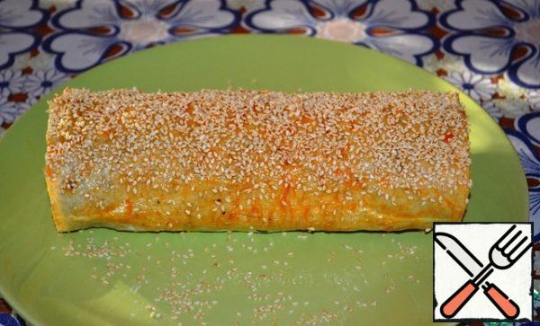 Lubricate the cooled roll with ketchup. It is very convenient to do this with a cooking brush. I had yellow tomato ketchup, my own canned food. Sprinkle with Golden sesame seeds on top.