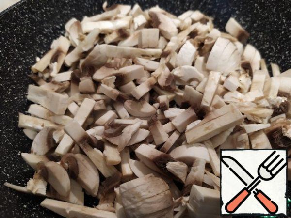 Clean the mushrooms, cut into strips and send them to a dry pan with a good non-stick coating. Over high heat, fry until liquid appears (about 5-7 minutes). Recline, to drain the excess liquid, let cool slightly.