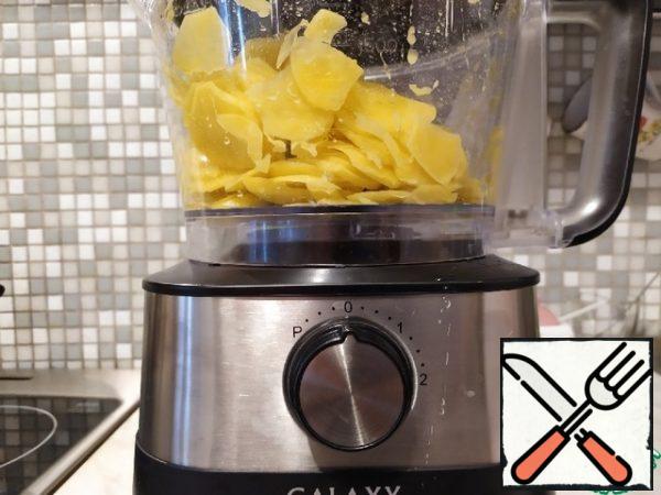 Peel the potatoes and cut into slices using a food processor.