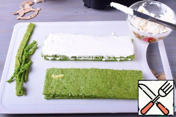 Cut the cake into 4 identical rectangles. Smear the first rectangle with cottage cheese and cover with the second rectangle, slightly pressing it with your hand. We will do this with all the layers, but the topmost (fourth) cake is not necessary to lubricate the cheese.