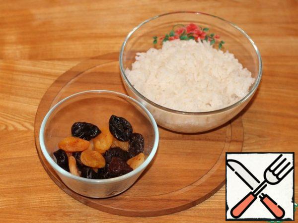 Boil the rice until half cooked. Pour dried apricots and prunes with hot water, give the fruits time to steam.
