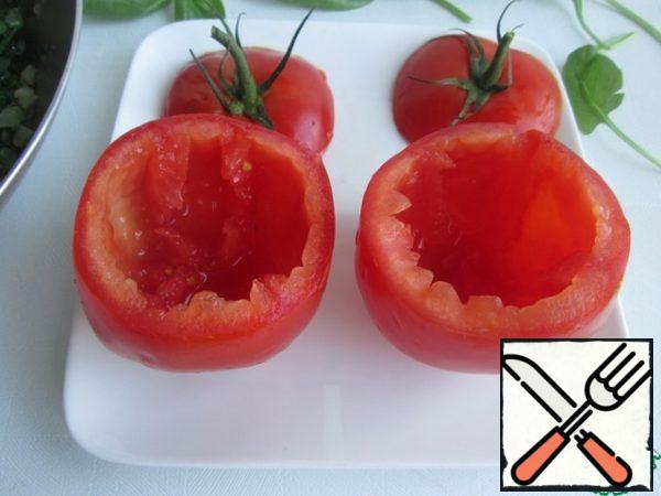 Cut off the tops of tomatoes and carefully remove the core with a spoon, it will not be useful in further cooking. If desired, you can add to the form when baking tomatoes.Place the tomatoes on a baking sheet or grill and place in the oven, preheated to 200 degrees, for 5 minutes.