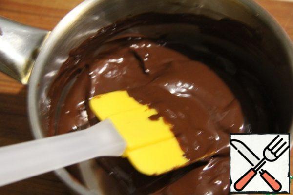 Prepare the glaze: melt the chocolate in a water bath, add the vegetable oil and mix everything.