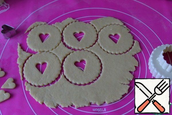 I thought the holes were big and the second batch made holes in the form of "hearts". Cut out the dough is not rolled out, and also baked. Since the dough is warmer when re-rolling, the structure changes. Put the cookie blanks on a baking sheet covered with parchment.