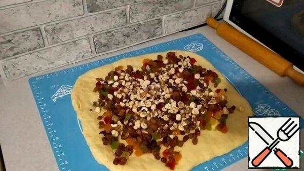 Come up the dough to knead, put on the work surface and roll out a little. Spread the prepared raisins and candied fruits on top, pre-draining the liquid, as well as chopped nuts. Mix the "filling" in the dough.