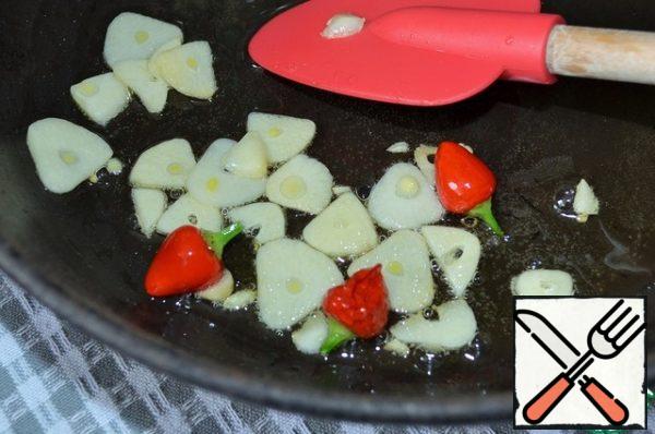 In olive oil, fry the garlic petals, hot pepper.