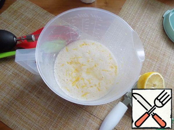 Next, pour the sunflower oil and sour cream. Whisk again. Remove the zest from half a lemon. Squeeze 2 tbsp lemon juice. Connect.