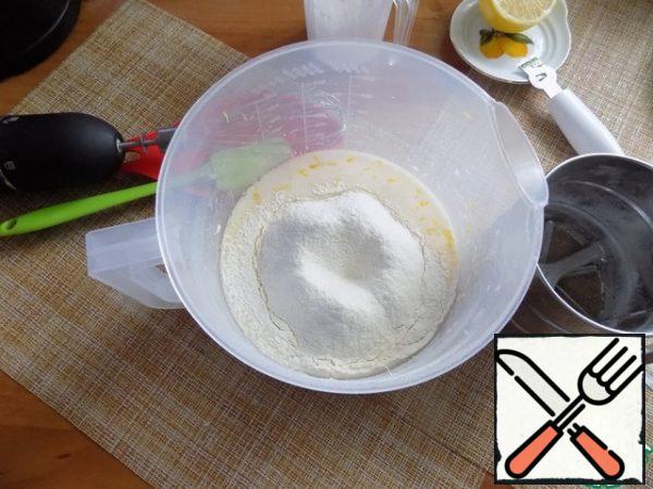 Mix the flour with the baking powder and sift into the mixture. With a whisk combine. I use baking powder with saffron. It will turn the color of the dough a little yellow. You can use any.